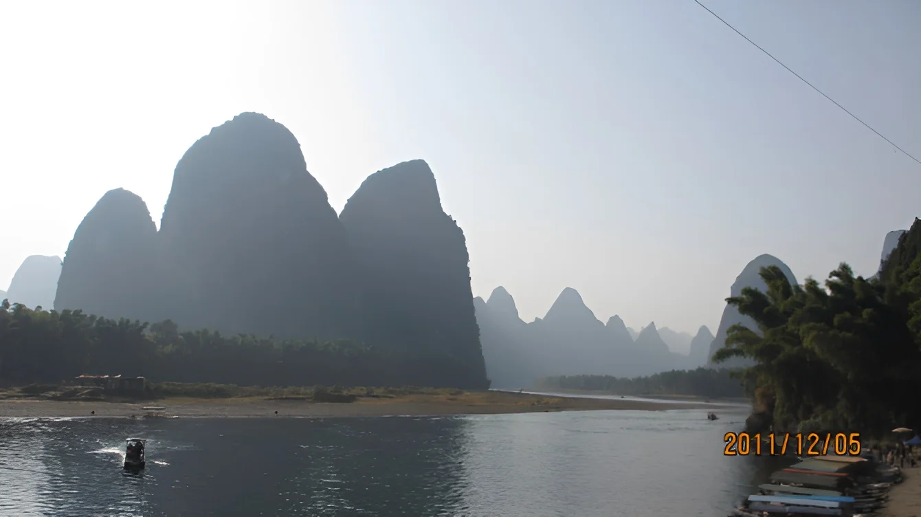 Karst peaks towering over the Li River with a small boat in the foreground, December 2011